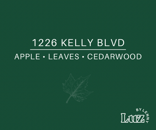 Deep green label reading “1226 Kelly Blvd” and “Apple • Leaves • Cedarwood,” with a subtle maple leaf illustration and Luz by Lenny logo.